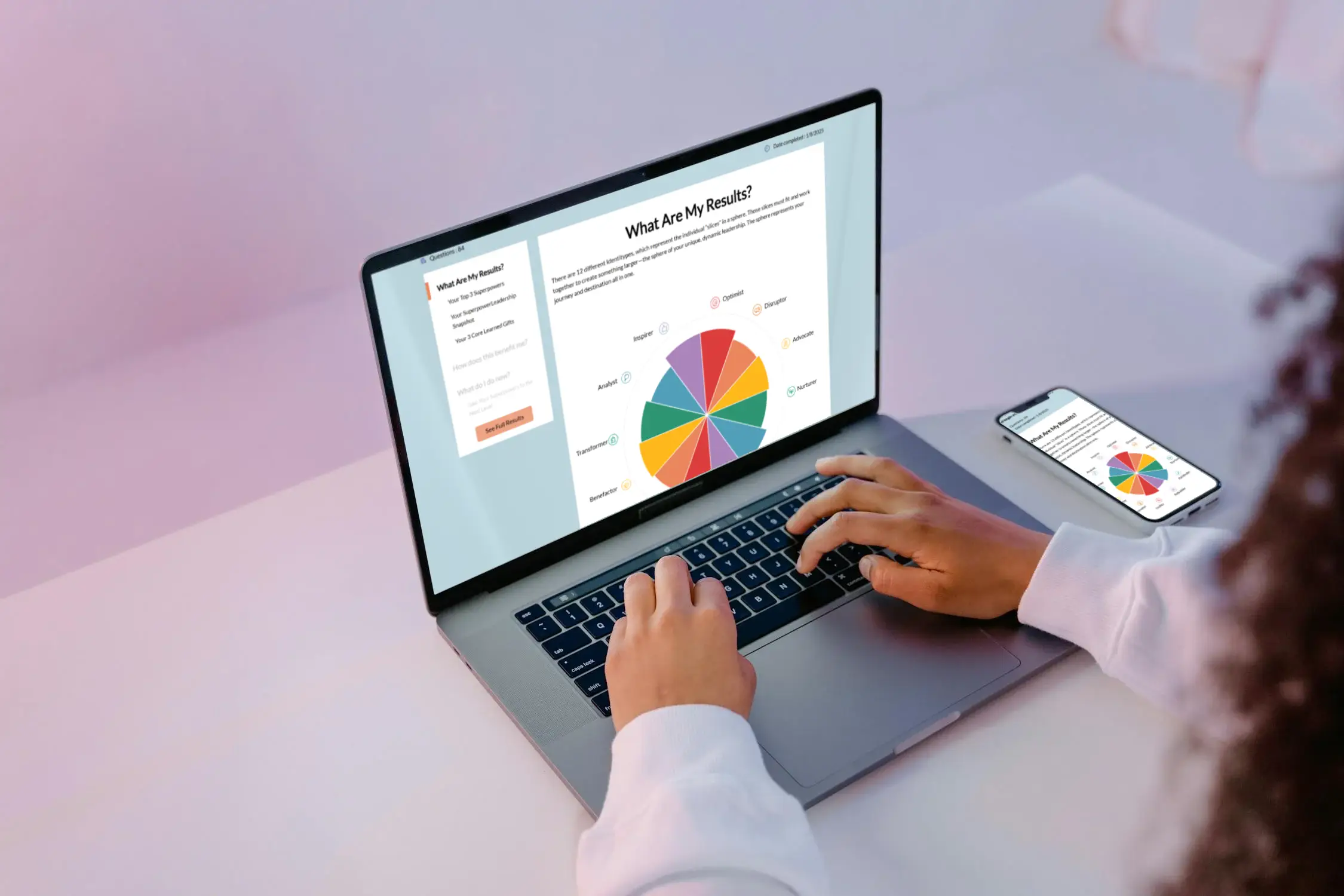 A person typing on a laptop displaying colorful pie chart results, with a matching display on a nearby smartphone.